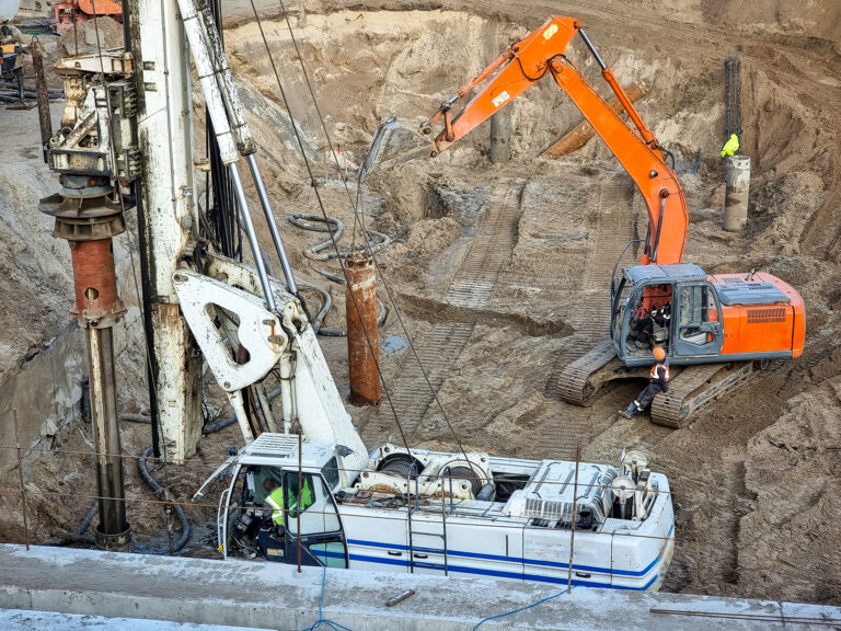 Closeup of heavy excavators and construction machines working on building site.